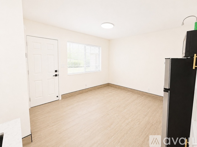 A room with a white door and a window with blinds.