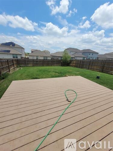 A wooden deck with a green hose on it.