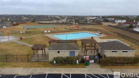 A pool area with a small building and a fence.