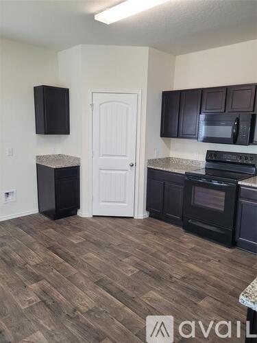 A kitchen with dark wood cabinets and a white door.
