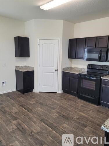 A kitchen with dark wood cabinets and a white door.