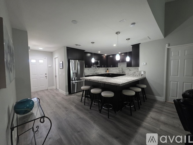 A kitchen with a bar area and stools.