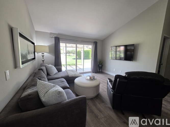 A living room with a grey couch and a white coffee table.