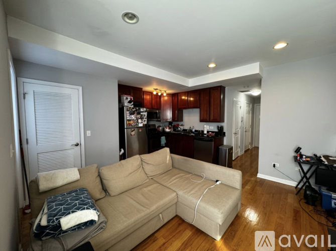 A living room with a couch and a kitchen in the background.