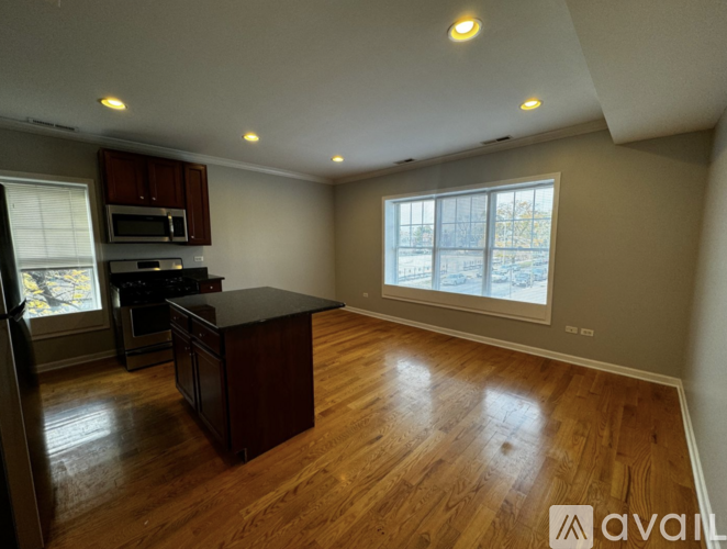 A kitchen with wooden floors and a large island in the middle.