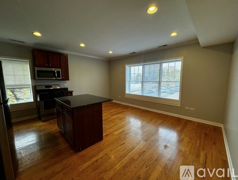 A kitchen with wooden floors and a large island in the middle.
