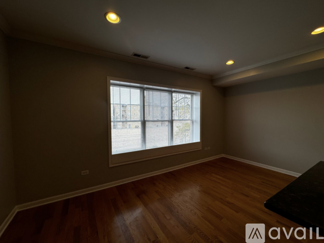 A room with wooden floors and a large window.