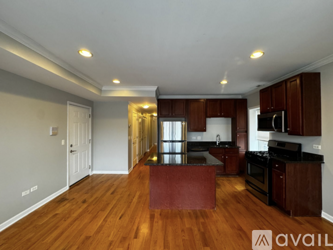 A kitchen with wooden floors and a central island.