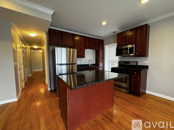 A kitchen with wooden cabinets and a black countertop.