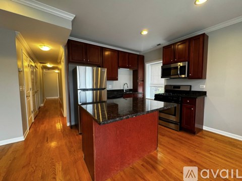 A kitchen with wooden cabinets and a black countertop.