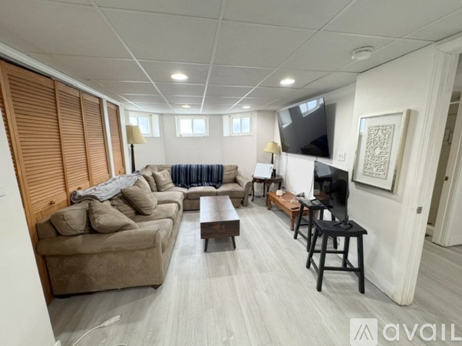 A living room with a couch, a coffee table, and a television.