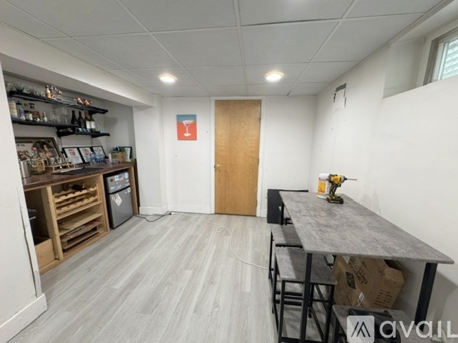A room with a grey table and a brown door.