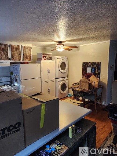 A room with boxes and a ceiling fan.