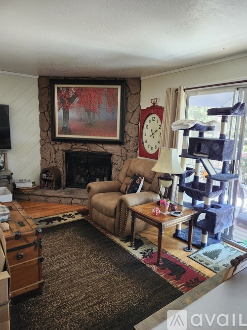 A living room with a fireplace and a painting above it.