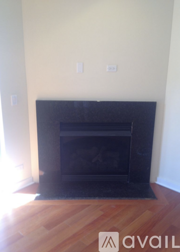 A black fireplace in a room with wooden floors.