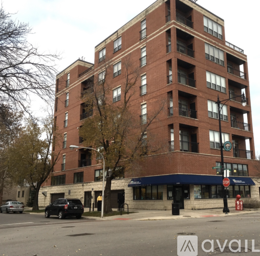 A tall brick building with a blue awning in front.