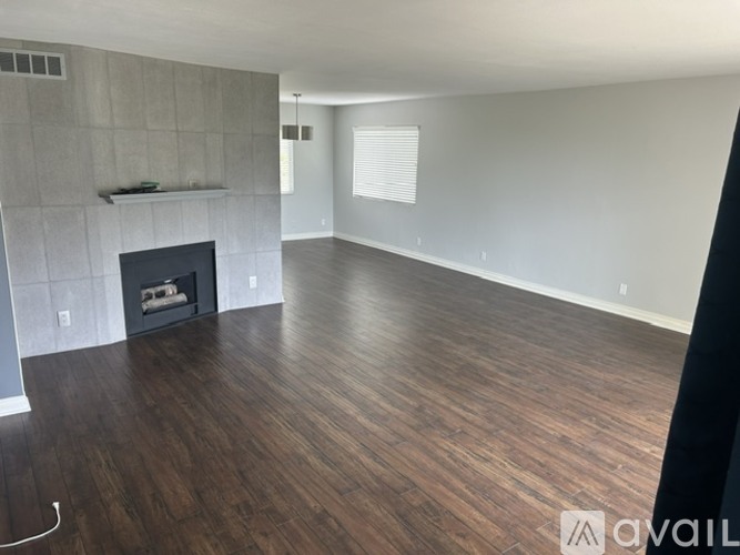 A spacious living room with a fireplace and wooden flooring.