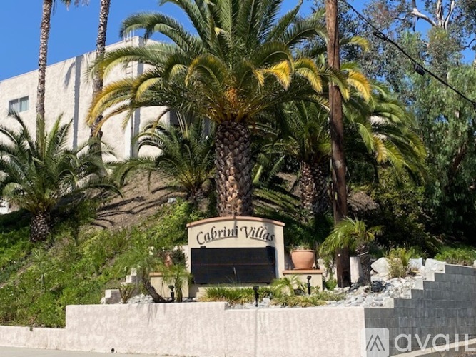 A sign that says Cabrillo Villas in front of some trees.