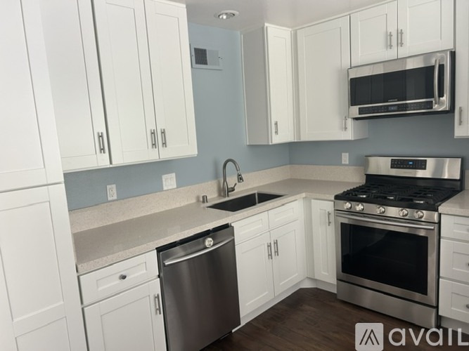 A kitchen with white cabinets and a stainless steel dishwasher.