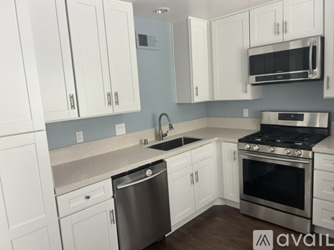 A kitchen with white cabinets and a stainless steel dishwasher.