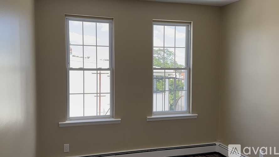 Two windows in a room with beige walls.