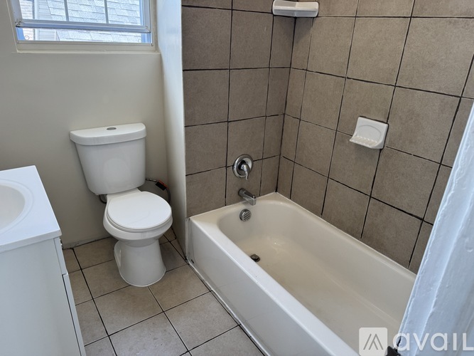 A white toilet sits next to a bathtub in a bathroom.