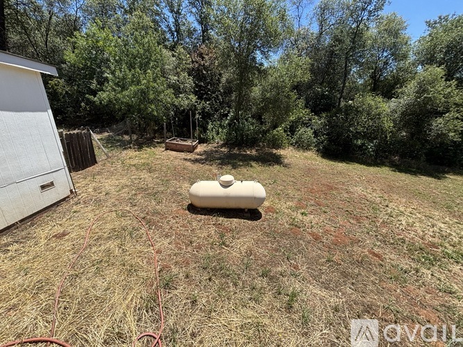 A white container is sitting in the middle of a grassy field.
