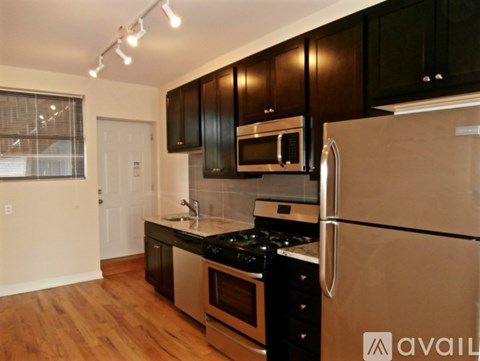 A kitchen with black cabinets and stainless steel appliances.