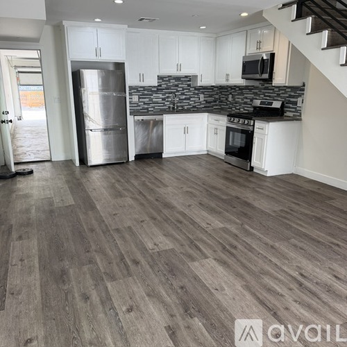 A kitchen with a stainless steel refrigerator and a stainless steel dishwasher.