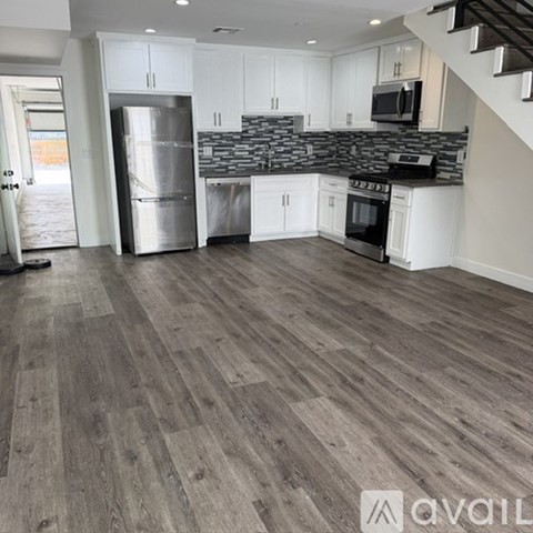 A kitchen with a stainless steel refrigerator and a stainless steel dishwasher.