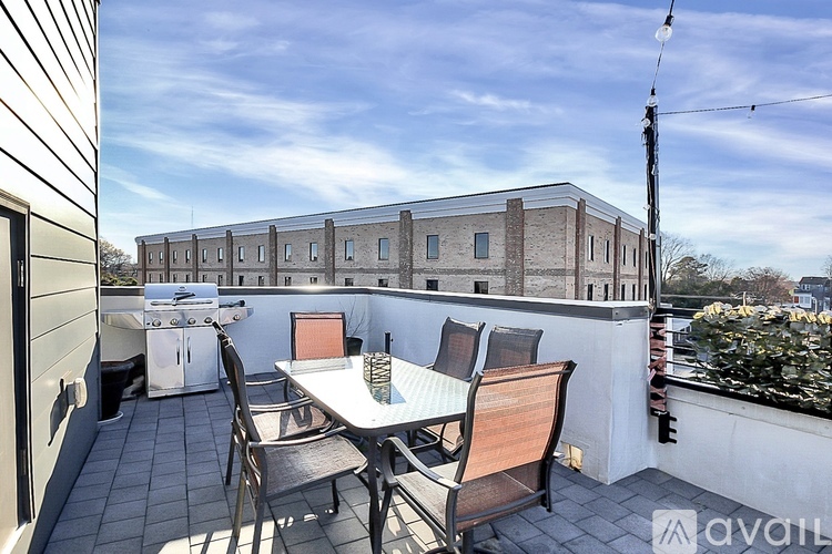 A balcony with a table and chairs overlooks a building.