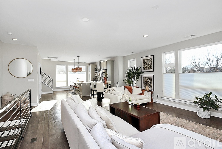 A modern living room with a white sofa and a wooden coffee table.