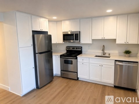 A kitchen with white cabinets and stainless steel appliances.