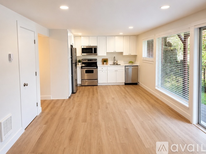 A kitchen with wooden floors and white walls.
