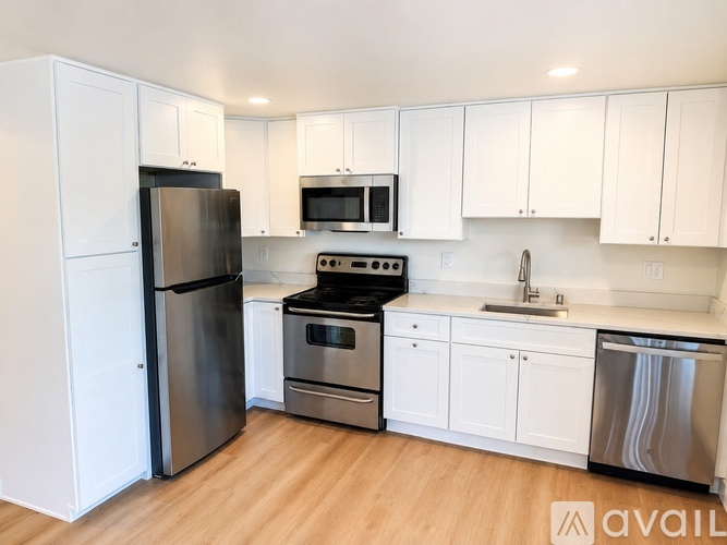 A kitchen with white cabinets and stainless steel appliances.
