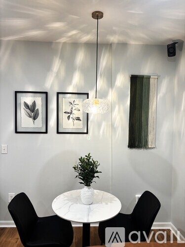 A dining room with a white table and black chairs.