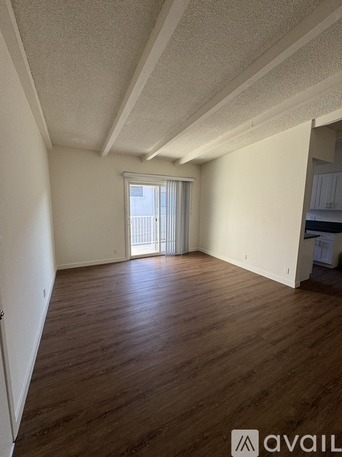 A room with wooden floors and a window with blinds.