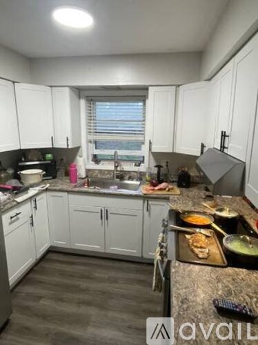 A kitchen with white cabinets and a granite countertop.