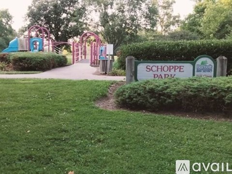 A sign that says Schoppe Park is in front of a playground.