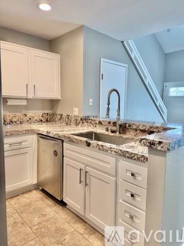 A kitchen with granite countertops and white cabinets.