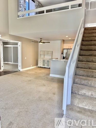 A spacious living room with a staircase leading to the upper floor.
