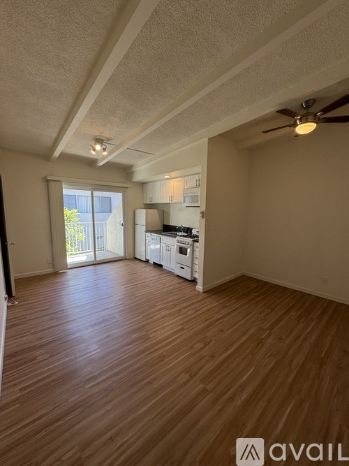 A room with wooden flooring and a ceiling fan.