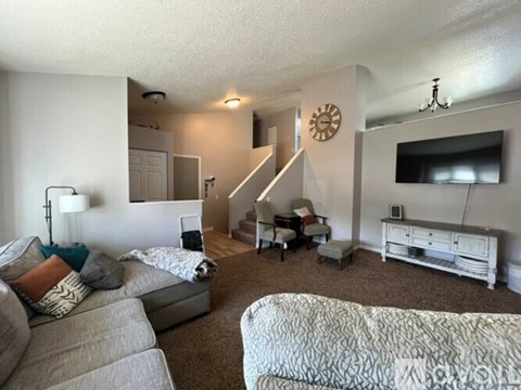 A living room with a grey couch and a white sofa.