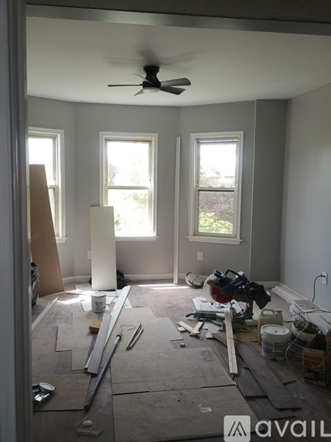 A room under construction with a ceiling fan and unfinished walls.