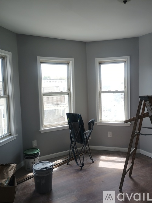 A room with two windows and a ladder.