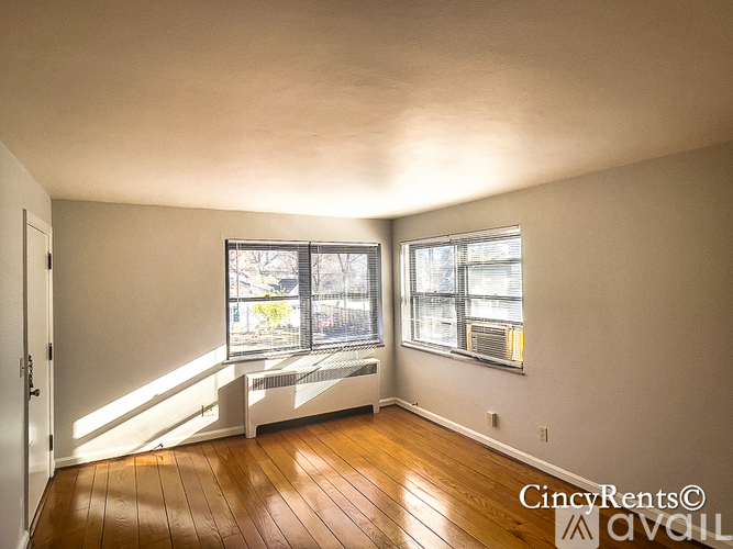 A room with wooden floors and two windows.