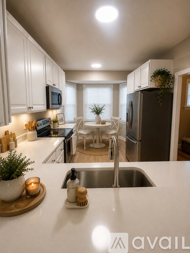 A kitchen with white cabinets and a stainless steel refrigerator.