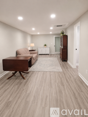 A living room with a brown chair and a white cabinet.