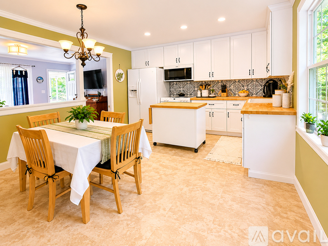 A kitchen with a table and chairs in the middle of the room.