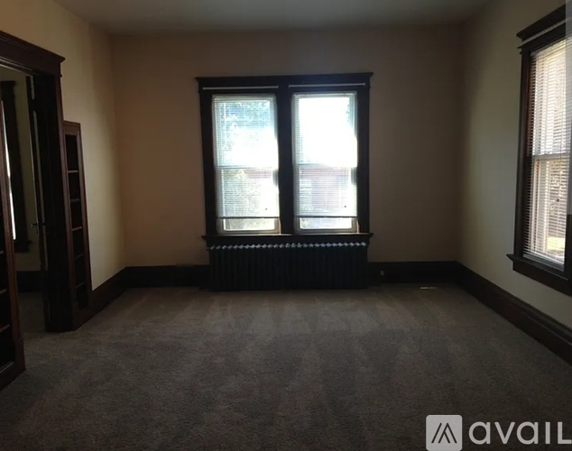 A room with a large window and a radiator on the floor.